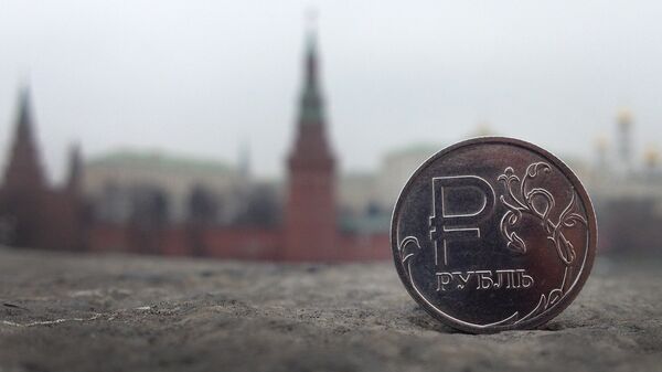 A Russian ruble coin is pictured in front of the Kremlin in in central Moscow, on November 6, 2014 - Sputnik Afrique