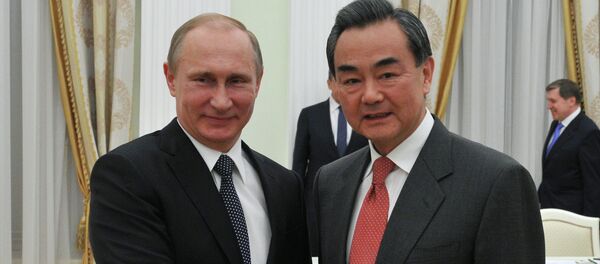 Президент Россиии Владимир Путин (слева) и министр иностранных дел Китая Ван И во время встречи в Кремле. - Sputnik Afrique