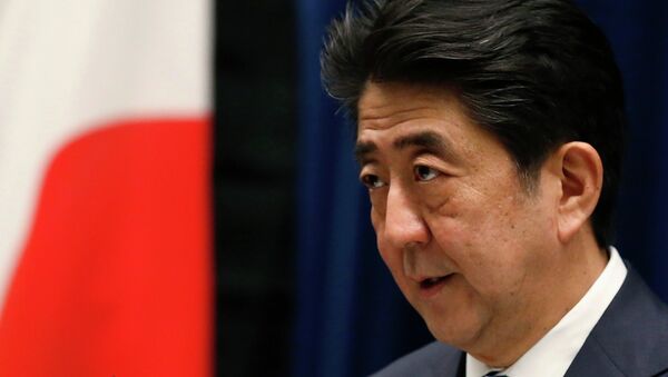 Japan's Prime Minister Shinzo Abe speaks next to the Japanese national flag - Sputnik Afrique