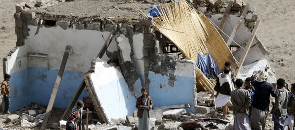 People gather on the wreckage of a house destroyed by an air strike in the Bait Rejal village west of Yemen's capital Sanaa April 7, 2015. - Sputnik Afrique