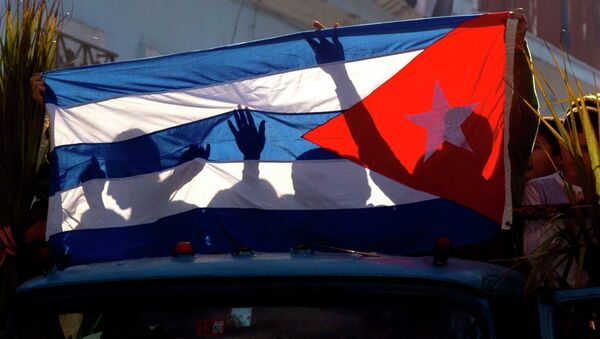 Children's shadows are cast on a Cuban national flag as they take part in a caravan tribute marking the 56th anniversary of the original street party that greeted a triumphant Castro and his rebel army, in Regla, Cuba, Thursday, Jan. 8, 2015 - Sputnik Afrique