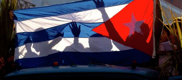 Children's shadows are cast on a Cuban national flag as they take part in a caravan tribute marking the 56th anniversary of the original street party that greeted a triumphant Castro and his rebel army, in Regla, Cuba, Thursday, Jan. 8, 2015 - Sputnik Afrique