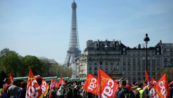 People holding flags of the CGT workers' union take part in a protest march on the Esplanade des Invalides, with the Eiffel Tower in background, as part of a national mobilization against the government's austerity measures, and for alternatives reforms favoring better salaries and jobs, on April 9, 2015 in Paris. - Sputnik Afrique