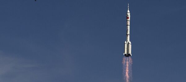 The Long March 2F rocket carrying the Shenzhou 10 capsule blasts off from the Jiuquan Satellite Launch Center as a bird flies, in Jiuquan, northwest China's Gansu Province The Long March 2F rocket carrying the Shenzhou 10 capsule blasts off from the Jiuquan Satellite Launch Center as a bird flies, in Jiuquan, northwest China's Gansu Province - Sputnik Afrique