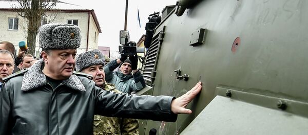 Ukraine's President Petro Poroshenko inspects a British Saxon military vehicle for its bullet proof capabilities at the National Guard Training Center in Novy Petrivtsy, Ukraine, Friday, Feb. 13, 2015 - Sputnik Afrique