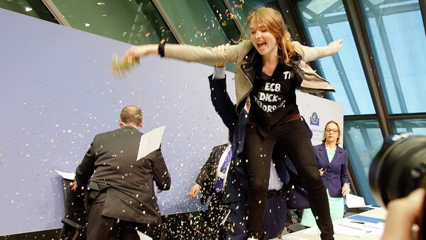 An activist stands on the table of the podium throwing paper at ECB President Mario Draghi, left covered, during a press conference of the European Central Bank in Frankfurt, Germany, Wednesday, April 15, 2015 - Sputnik Afrique