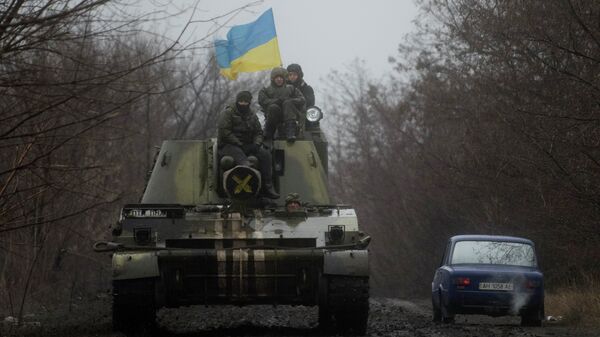 Ukrainian servicemen ride atop an armored vehicle with a Ukrainian flag, on the outskirts of Donetsk, Ukraine - Sputnik Afrique