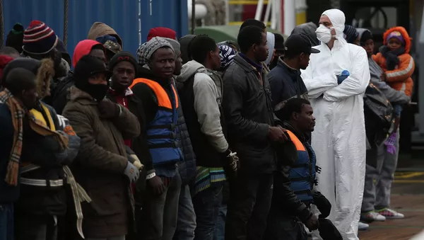 A rescue worker (R) checks migrants as they arrive on the boat Nos Taurus Genova at the Sicilian harbor of Pozzallo, February 16, 2015. - Sputnik Afrique