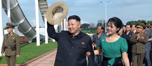 North Korean leader Kim Jong Un, center, accompanied by his wife Ri Sol Ju, right, waves to the crowd as they inspect the Rungna People's Pleasure Ground in Pyongyang - Sputnik Afrique