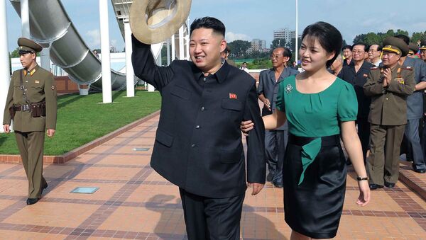 North Korean leader Kim Jong Un, center, accompanied by his wife Ri Sol Ju, right, waves to the crowd as they inspect the Rungna People's Pleasure Ground in Pyongyang - Sputnik Afrique