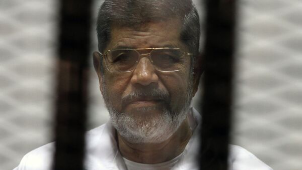 Egyptian ousted Islamist president Mohamed Morsi looks on from behind the defendants cage during his trial. File photo. - Sputnik Afrique