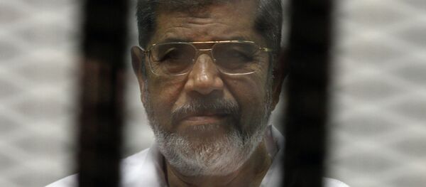 Egyptian ousted Islamist president Mohamed Morsi looks on from behind the defendants cage during his trial. File photo. - Sputnik Afrique