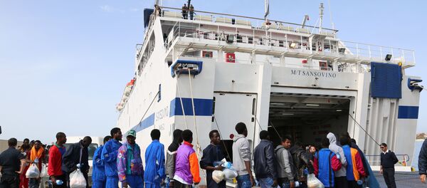 Migrants board on a ferry as they leave the Island of Lampedusa, Southern Italy, to be transferred in Porto Empedocle, Sicily, Friday, April 17, 2015. - Sputnik Afrique