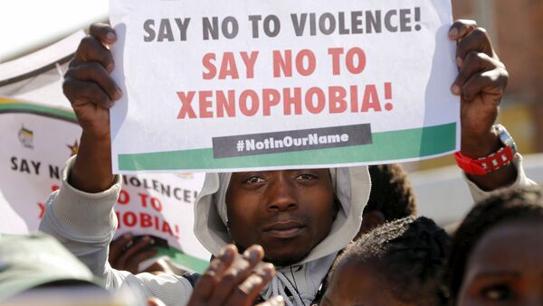 Demonstrators hold placards outside a court in Johannesburg's Alexandra township as four men appeared in court for the killing of a Mozambican man, April 21, 2015. - Sputnik Afrique