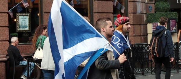 Yes campaigners carry flags on the day Scottish residents decide the future political direction their country will take in Glasgow,Scotland on September 18, 2014 - Sputnik Afrique
