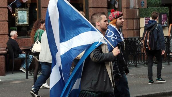 Yes campaigners carry flags on the day Scottish residents decide the future political direction their country will take in Glasgow,Scotland on September 18, 2014 - Sputnik Afrique