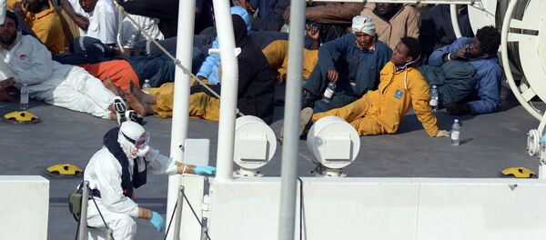 Survivors of an accident in which a fishing boat carrying migrants capsized off the Libyan coast, sit on the deck of the Italian Coast Guard vessel Bruno Gregoretti at Boiler Wharf, Senglea in Malta on April 20, 2015. - Sputnik Afrique