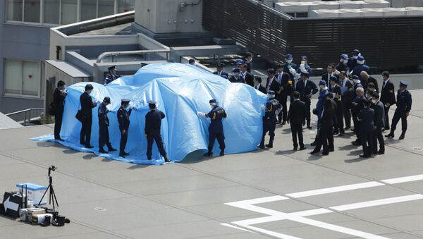 Police and security officials stand around a tarpaulin covering a drone on the roof of Prime Minister Shinzo Abe's official residence in Tokyo April 22, 2015 - Sputnik Afrique