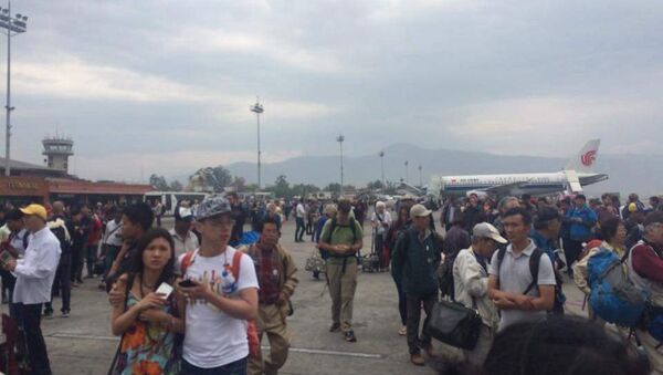 People stand on the runway outside the International Terminal after a earthquake hit, at Tribhuvan International Airport, Kathmandu, Nepal, April 25, 2015 - Sputnik Afrique