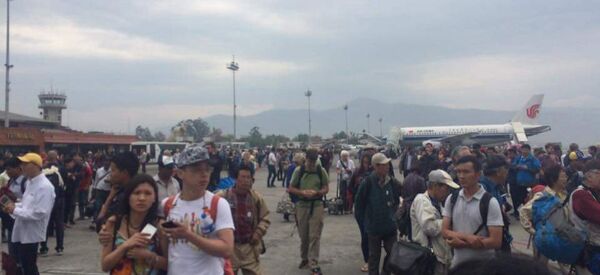 People stand on the runway outside the International Terminal after a earthquake hit, at Tribhuvan International Airport, Kathmandu, Nepal, April 25, 2015 - Sputnik Afrique