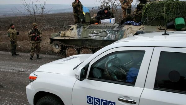 A vehicle of Special Monitoring Mission of the Organization for Security and Cooperation (OSCE) to Ukraine rides along a convoy of Ukrainian armed forces in Paraskoviyvka, eastern Ukraine, February 26, 2015. - Sputnik Afrique