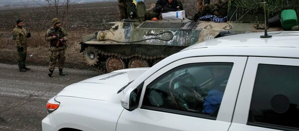 A vehicle of Special Monitoring Mission of the Organization for Security and Cooperation (OSCE) to Ukraine rides along a convoy of Ukrainian armed forces in Paraskoviyvka, eastern Ukraine, February 26, 2015. - Sputnik Afrique