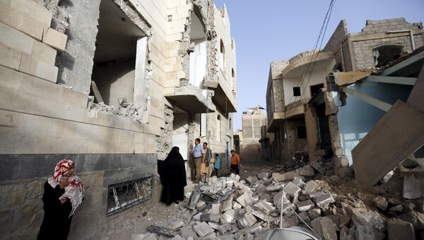 People look at houses damaged by an air strike in Sanaa April 26, 2015. - Sputnik Afrique
