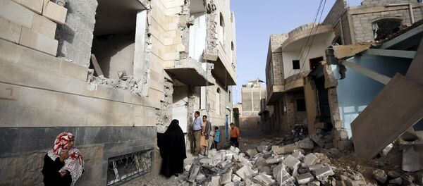 People look at houses damaged by an air strike in Sanaa April 26, 2015. - Sputnik Afrique