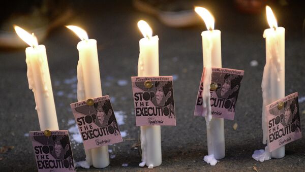 Candles and portraits of Filipina Mary Jane Veloso, who is due for execution in Indonesia, are seen during the vigil in front of the Indonesian embassy in Manila on April 27, 2015. - Sputnik Afrique