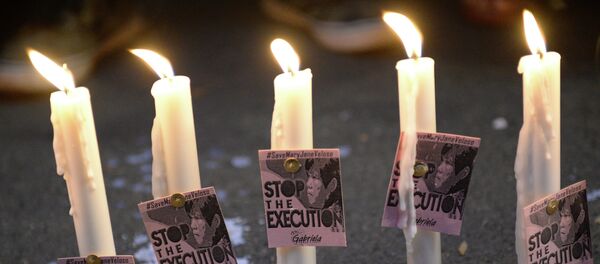 Candles and portraits of Filipina Mary Jane Veloso, who is due for execution in Indonesia, are seen during the vigil in front of the Indonesian embassy in Manila on April 27, 2015. - Sputnik Afrique