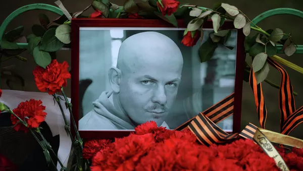 Flowers and candles laid at the Ukraine Embassy in Moscow in memory of journalist Oles Buzina killed in Kiev - Sputnik Afrique