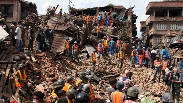 People watch as rescuers search for bodies at the site of a building which collapsed during an earthquake in Bhaktapur near of Kathmandu, Nepal in this Red Cross handout picture taken on April 29, 2015 - Sputnik Afrique