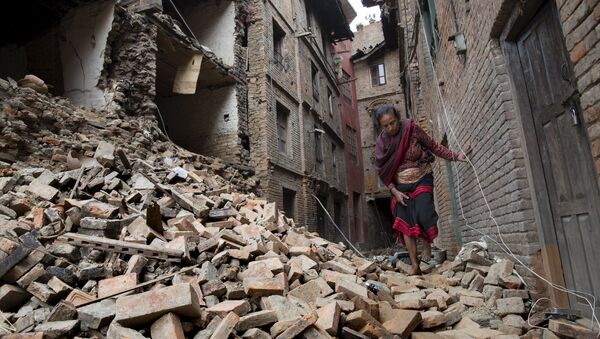 A woman walks across the rubble of a collapsed building following an earthquake in Bhaktapur near Kathmandu, Nepal in this Red Cross handout picture taken on April 28, 2015. - Sputnik Afrique