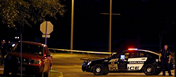 A police officer stands near the suspects' vehicle after a shooting outside the Muhammad Art Exhibit and Contest sponsored by the American Freedom Defense Initiative in Garland, Texas - Sputnik Afrique