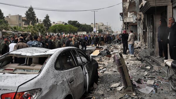 Syrian residents and security forces inspect the damage following a car bomb explosion on April 10, 2015, in the government-controlled majority Alawite neighbourhood of Hay al-Arman, located on the outskirts of the Zahraa district in Homs city - Sputnik Afrique
