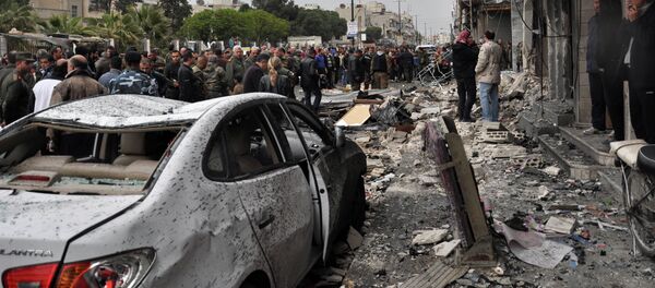 Syrian residents and security forces inspect the damage following a car bomb explosion on April 10, 2015, in the government-controlled majority Alawite neighbourhood of Hay al-Arman, located on the outskirts of the Zahraa district in Homs city - Sputnik Afrique