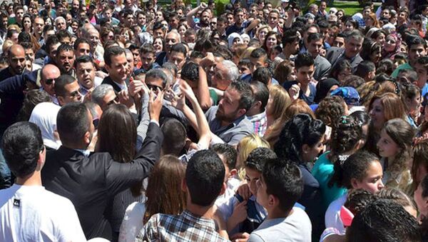 Le président Bachar al-Assad salue ses partisans lors d'un événement pour commémorer les martyrs dans une école le 6 mai 2015 - Sputnik Afrique