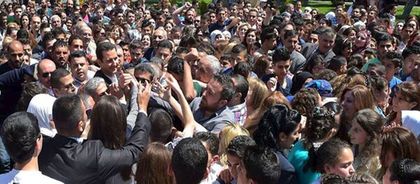 Le président Bachar al-Assad salue ses partisans lors d'un événement pour commémorer les martyrs dans une école le 6 mai 2015 - Sputnik Afrique