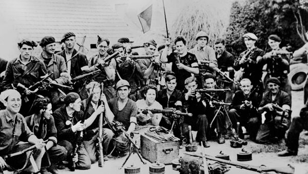 Un groupe de maquisards pose pour une photo avec armes et drapeau dans la cours d'une ferme en France, en un lieu indéterminé, durant l'été 1944, pendant la seconde Guerre mondiale. - Sputnik Afrique