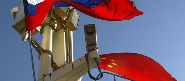 A worker places the Russian and Chinese flags outside Tiananmen Gate - Sputnik Afrique
