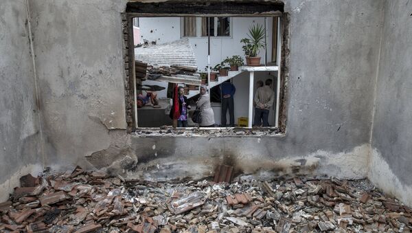 People stand by a destroyed house in Kumanovo, Macedonia, May 11, 2015 - Sputnik Afrique