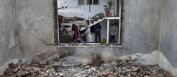People stand by a destroyed house in Kumanovo, Macedonia, May 11, 2015 - Sputnik Afrique