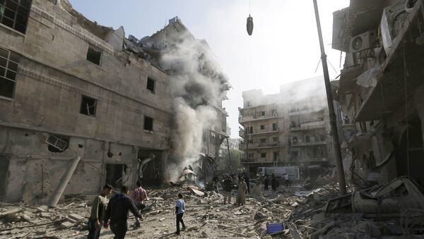 Residents walk amidst the rubble of a site damaged by what activists said was a barrel bomb dropped by forces loyal to Syria's president Bashar Al-Assad in Aleppo's al-Saliheen district - Sputnik Afrique