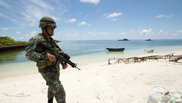 Filipino soldier Tychico Octobre patrols the shore of Pag-asa Island - Sputnik Afrique