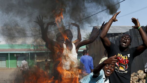 Protesters, who are against President Pierre Nkurunziza's decision to run for a third term, gesture in front of a burning barricade in Bujumbura, Burundi May 14, 2015. - Sputnik Afrique