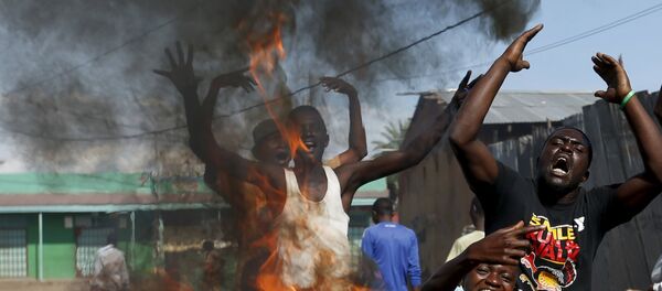 Protesters, who are against President Pierre Nkurunziza's decision to run for a third term, gesture in front of a burning barricade in Bujumbura, Burundi May 14, 2015. - Sputnik Afrique