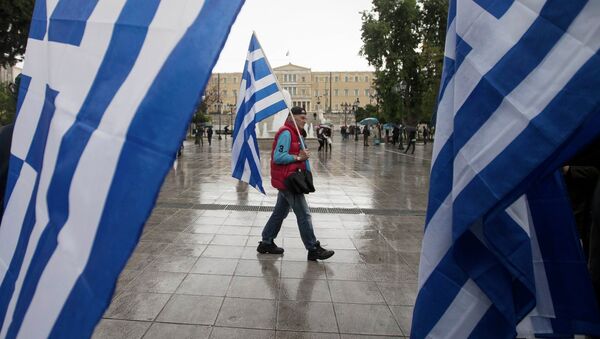 A man holding a Greek flag walks on central Syntagma square as the parliament is seen in the background, in Athens January 24, 2015 - Sputnik Afrique