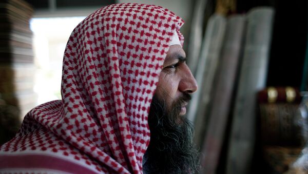 Salafi cleric Mohammed al-Shalabi, 48, widely known as Abu Sayyaf, talks during an interview with the Associated Press at a furniture store, owned by the head of Abu Sayyaf's clan, in the city of Ma'an, Jordan - Sputnik Afrique