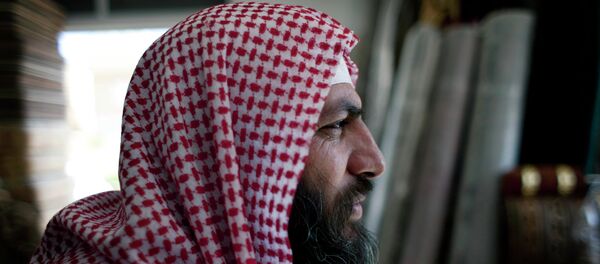 Salafi cleric Mohammed al-Shalabi, 48, widely known as Abu Sayyaf, talks during an interview with the Associated Press at a furniture store, owned by the head of Abu Sayyaf's clan, in the city of Ma'an, Jordan - Sputnik Afrique
