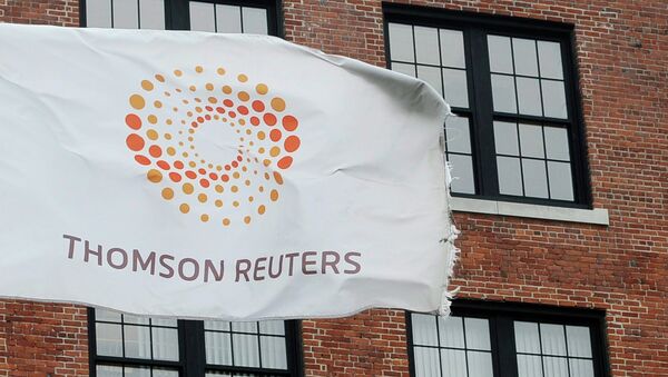 A flag displaying the Thomson Reuters logo flies outside a company building - Sputnik Afrique